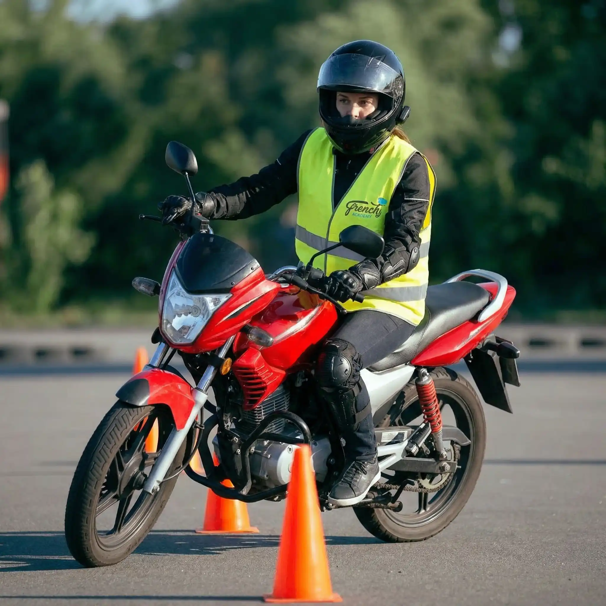 Élève moto en formation avec gilet French Academy et cônes de signalisation